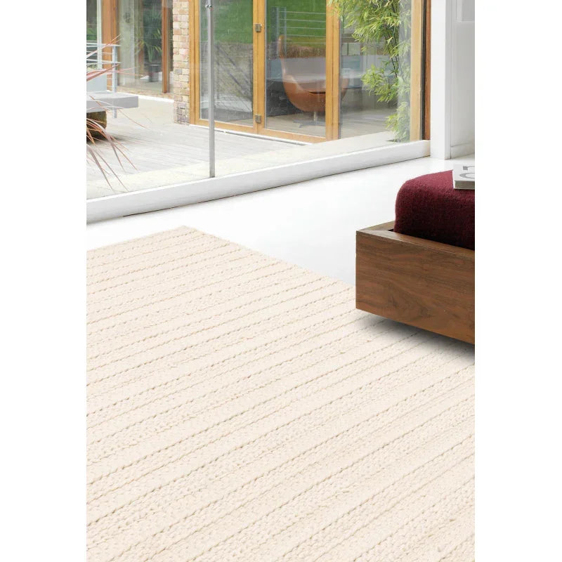 Ivory textured area rug in modern living room with glass doors and wooden furniture