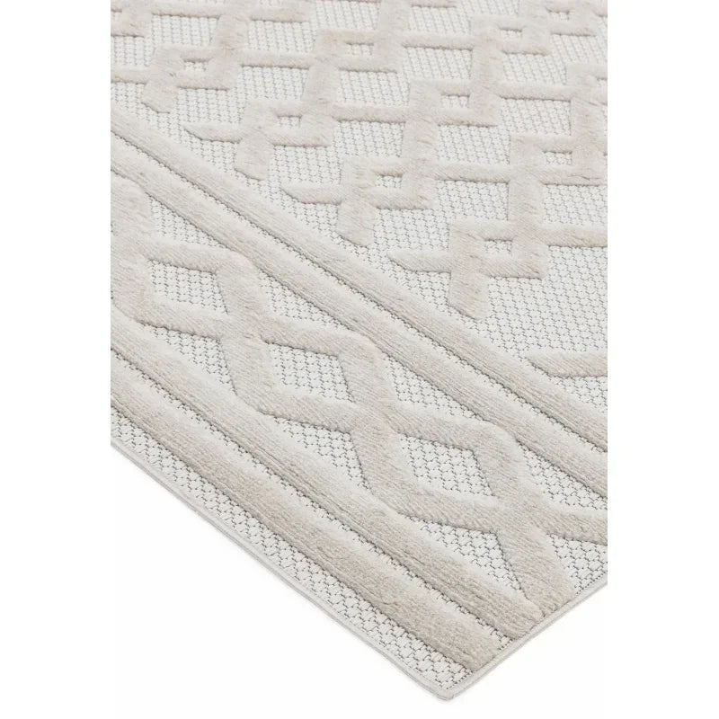 Beige textured rug with geometric pattern and soft raised detailing, corner view