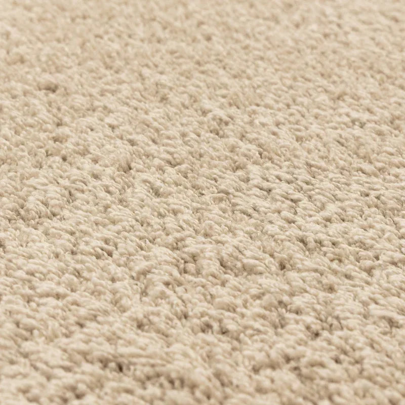 Closeup of beige carpet texture with soft, plush pile for home flooring