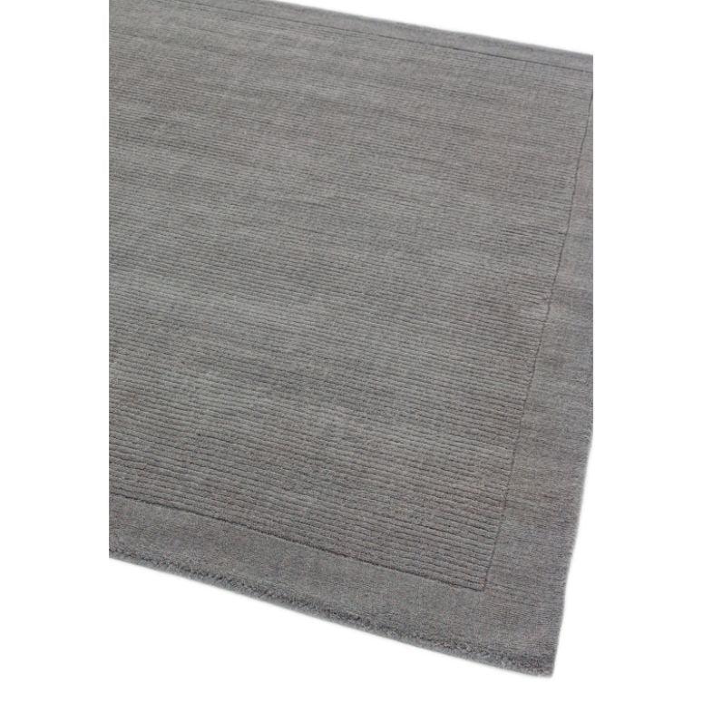 Grey area rug with subtle textured border and corner detail