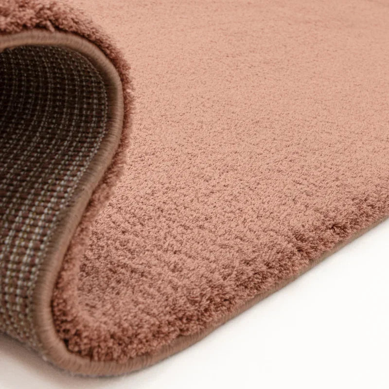 Closeup of blush pink rug with soft pile and woven backing