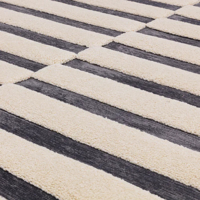 Close-up of modern striped area rug with cream and dark grey textured pattern