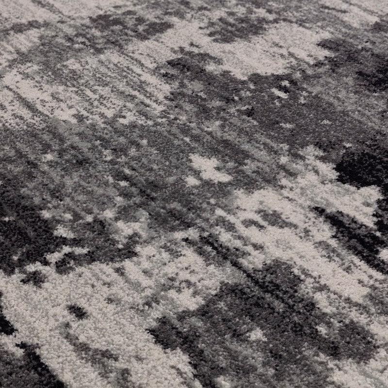 Grey and white abstract patterned rug with textured pile detail