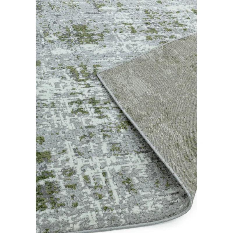 Modern patterned area rug in grey and green with corner flipped to show backing