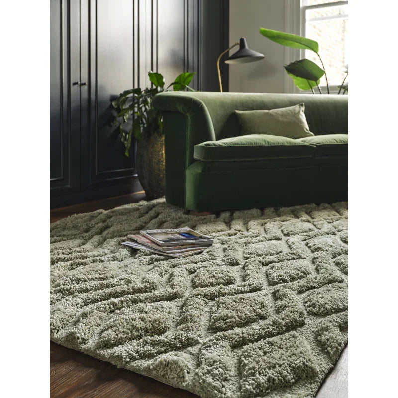Textured shaggy rug with geometric design in living room with green velvet sofa