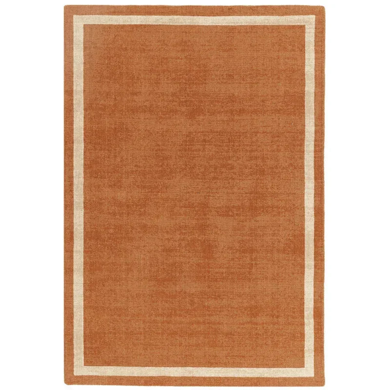 Terracotta area rug with simple cream border and flat weave texture