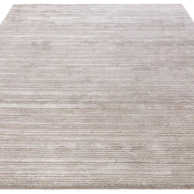 Large beige area rug with subtle horizontal stripes and a soft textured finish