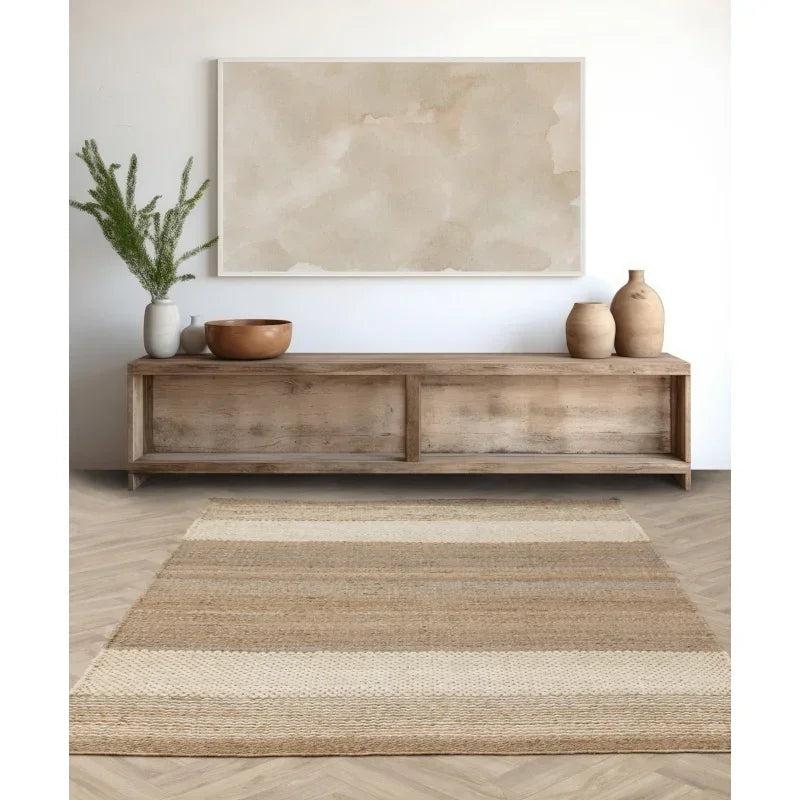 Striped jute rug on herringbone wood flooring in front of wooden sideboard with vases