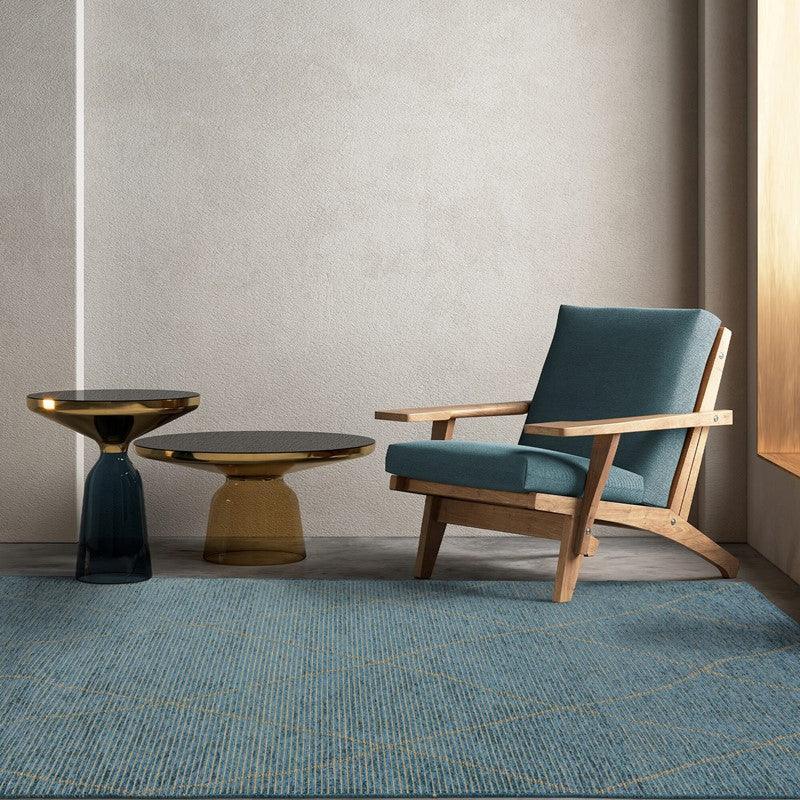 Wooden armchair with blue cushion beside two modern glass coffee tables on blue rug