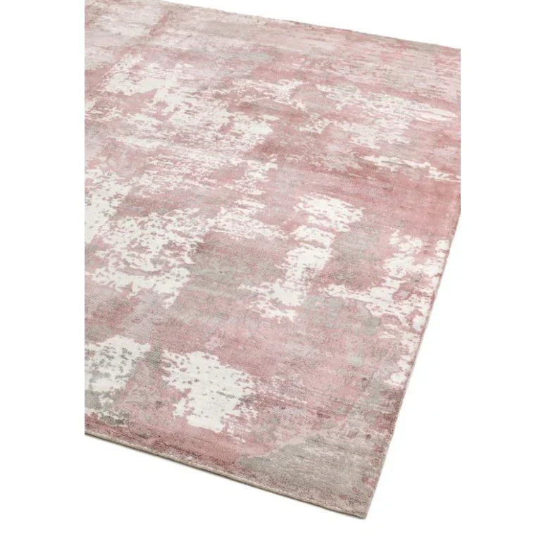 Modern area rug with pink, grey, and white abstract pattern, corner view