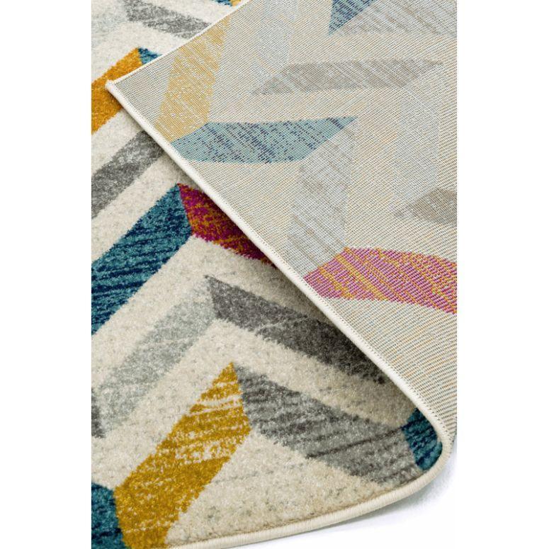 Chevron patterned area rug with blue, grey, yellow, and purple geometric shapes
