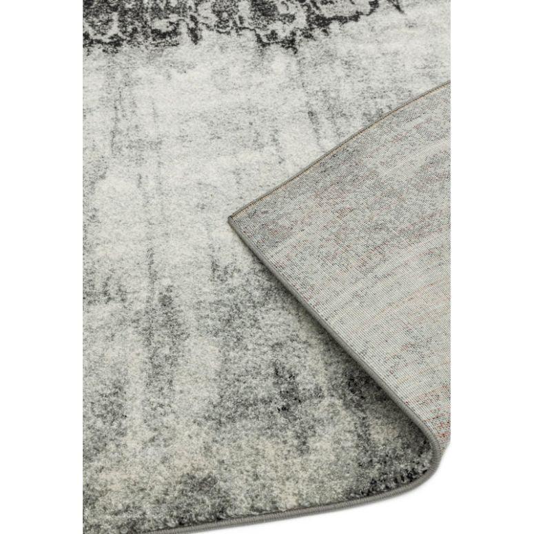 Grey abstract area rug with detailed corner fold showing textured pile and backing