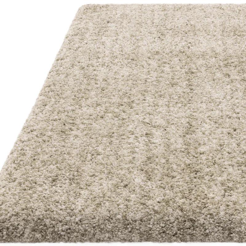 Light beige shaggy rug with thick pile, close-up corner view