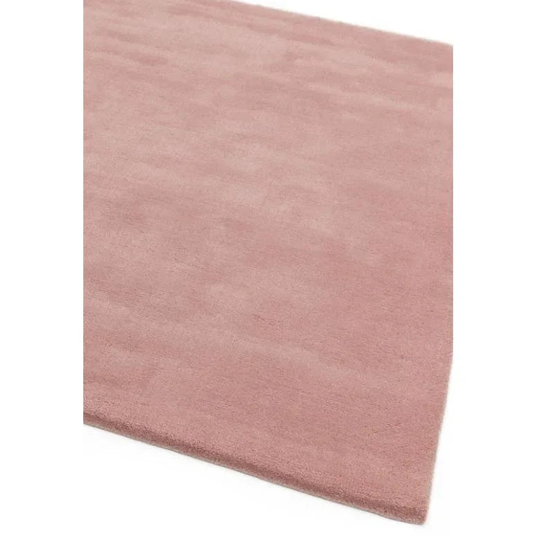 Blush pink area rug with soft texture and clean edge, shown from corner angle