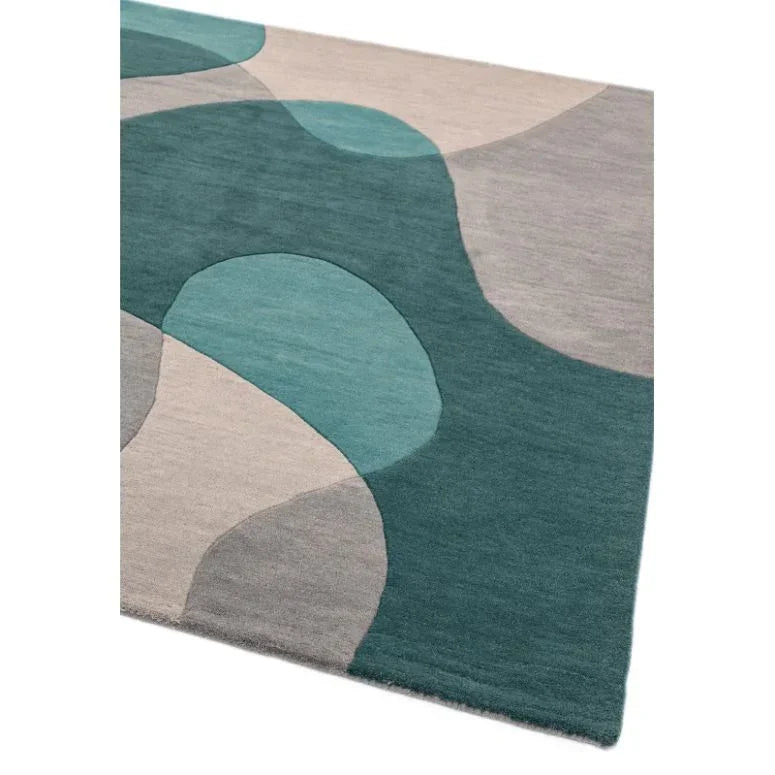 Modern area rug with abstract teal, grey and beige shapes, corner angle view