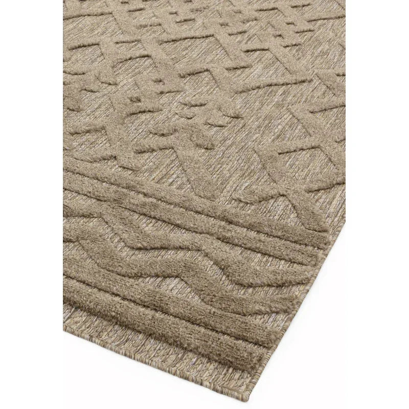 Beige textured rug with geometric pattern and raised detailing, close angle view
