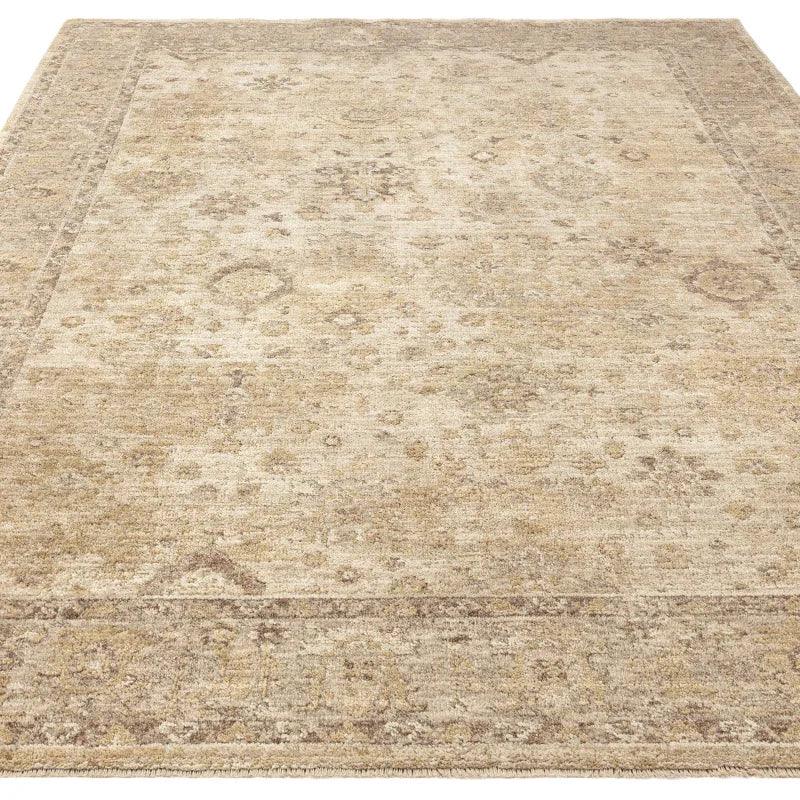 Beige patterned area rug with subtle traditional design and decorative border