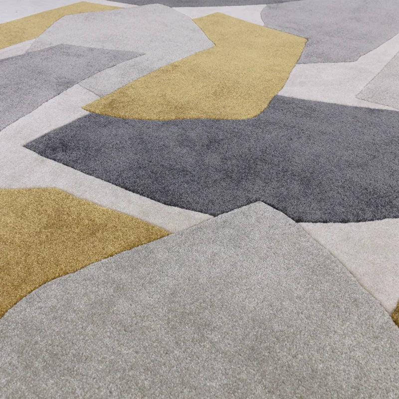 Modern area rug with abstract grey, white, and mustard yellow geometric pattern