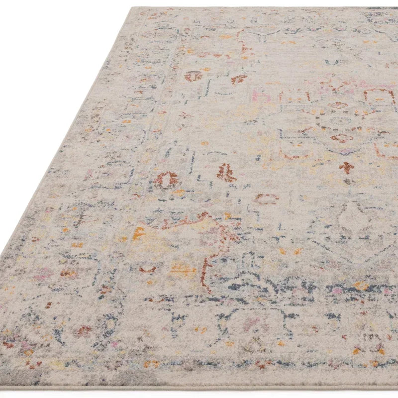 Beige patterned area rug with faded multicolour floral and geometric design, corner view