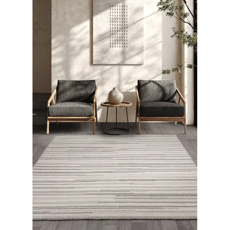 Striped grey area rug in modern living room with two wooden armchairs and side table