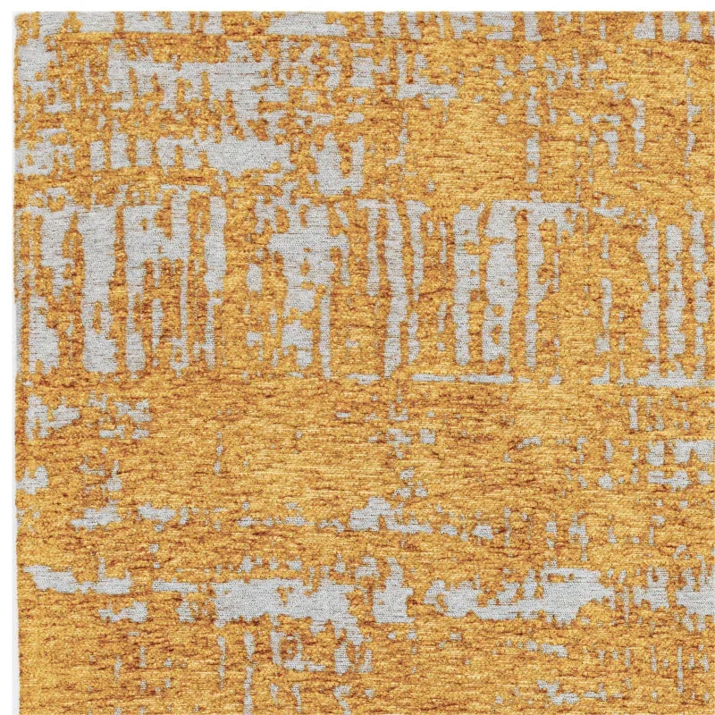 Abstract gold and grey area rug with modern textured pattern, partial top view