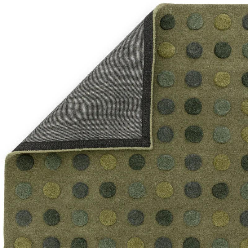 Green polka dot rug with textured pattern and visible corner showing backing