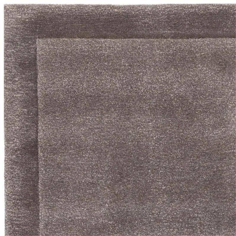 Close-up of a grey wool rug corner with textured finish