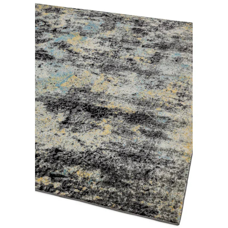 Modern abstract area rug with grey, yellow, and blue tones, angled corner view