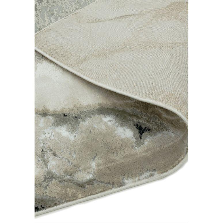 Neutral abstract area rug corner fold showing textured pile and backing