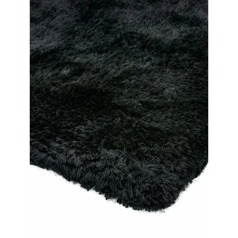 Black shaggy rug close-up showing soft textured pile and finished edge