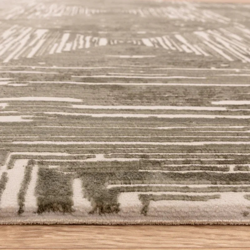 Close-up of modern area rug with textured grey and white pattern on wooden floor