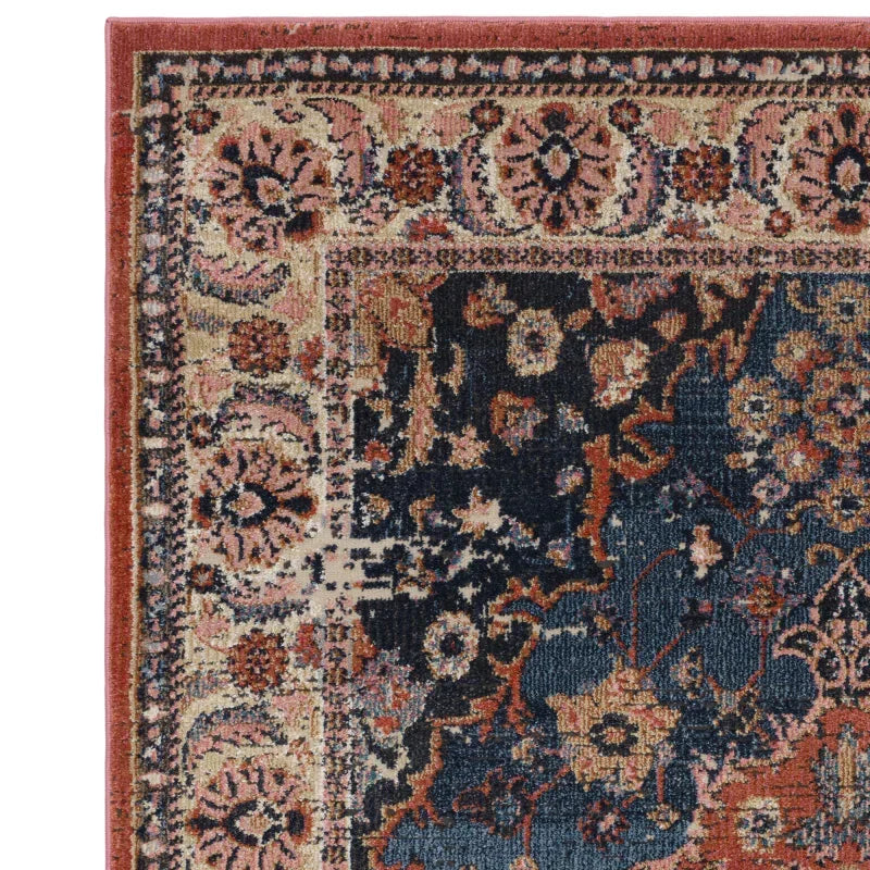 Corner view of vintage floral patterned rug with red, navy blue and beige details