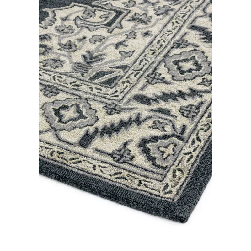 Grey patterned rug corner with textured floral and geometric border details