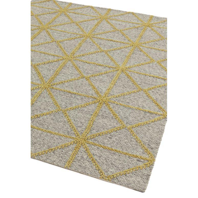 Grey area rug with yellow geometric diamond pattern, corner angle view