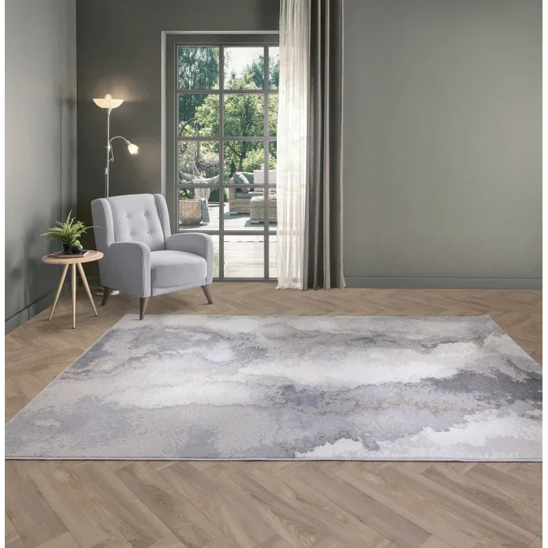 Modern grey abstract rug on wooden floor beside grey armchair and side table in living room