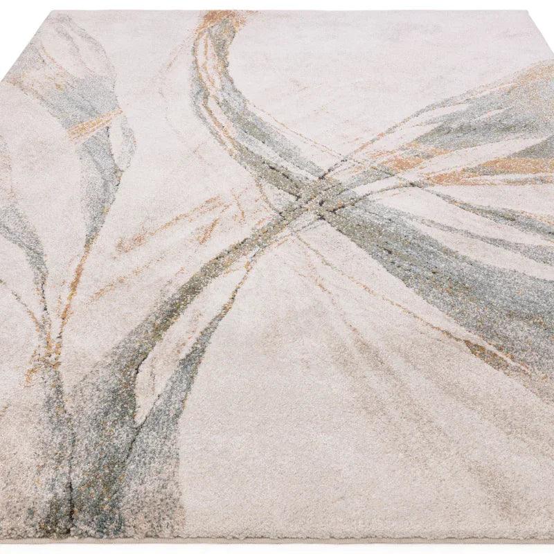 Modern abstract area rug in cream with grey and gold accents, close-up angled view