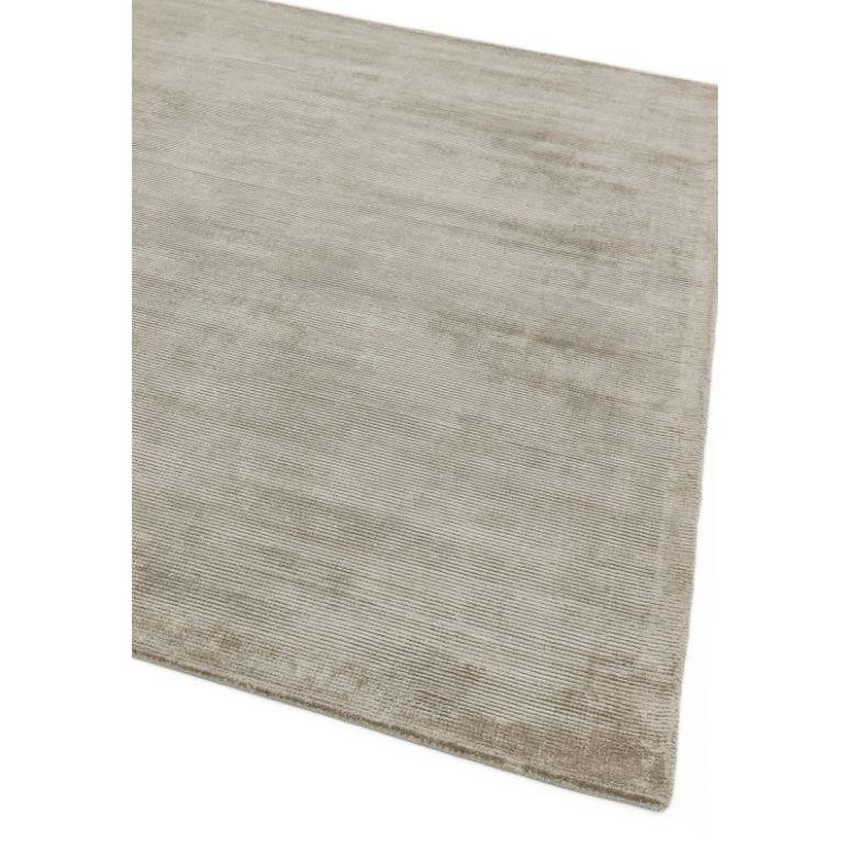 Beige area rug with subtle texture and soft finish, shown from corner angle