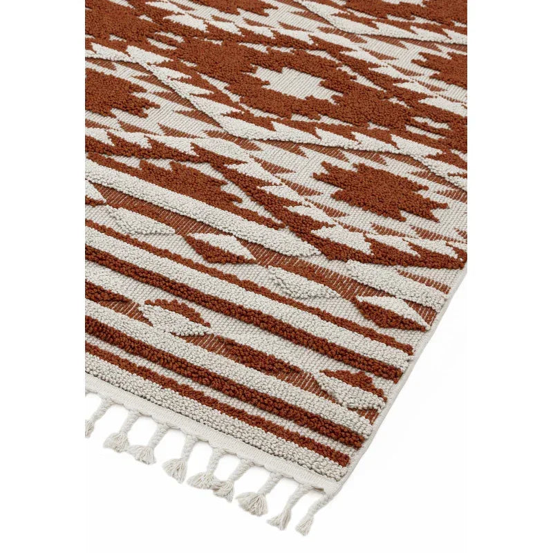 Geometric patterned rug with brown and cream colors and tassel fringe detail