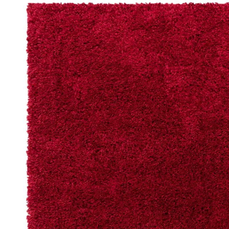 Close-up of red shaggy rug texture with soft pile