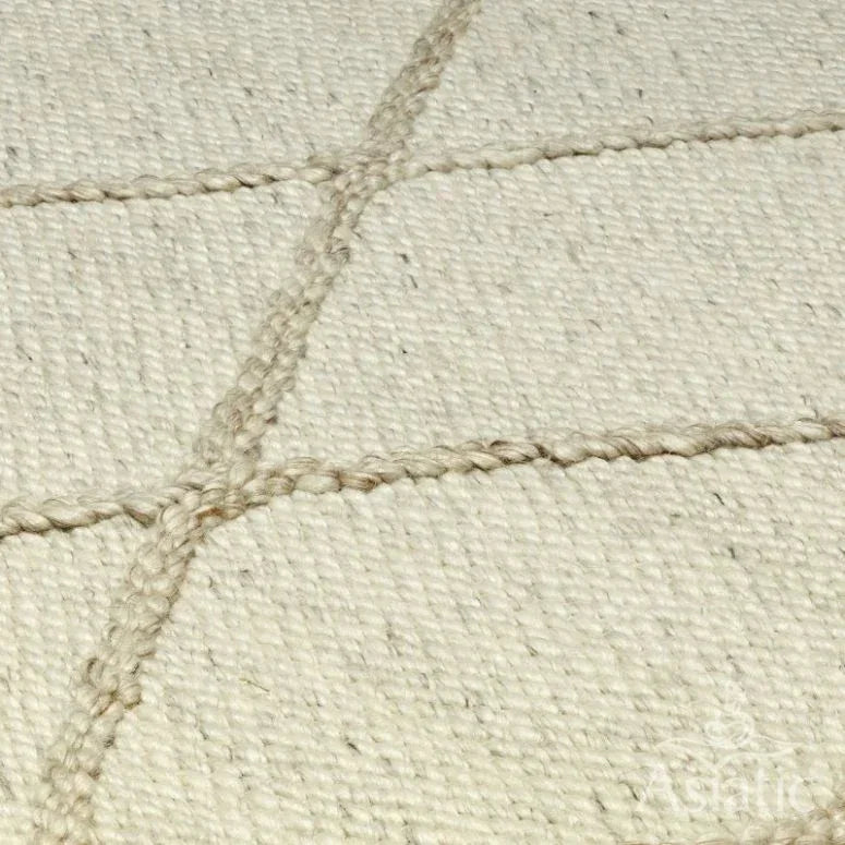 Cream wool rug with textured diamond pattern close-up