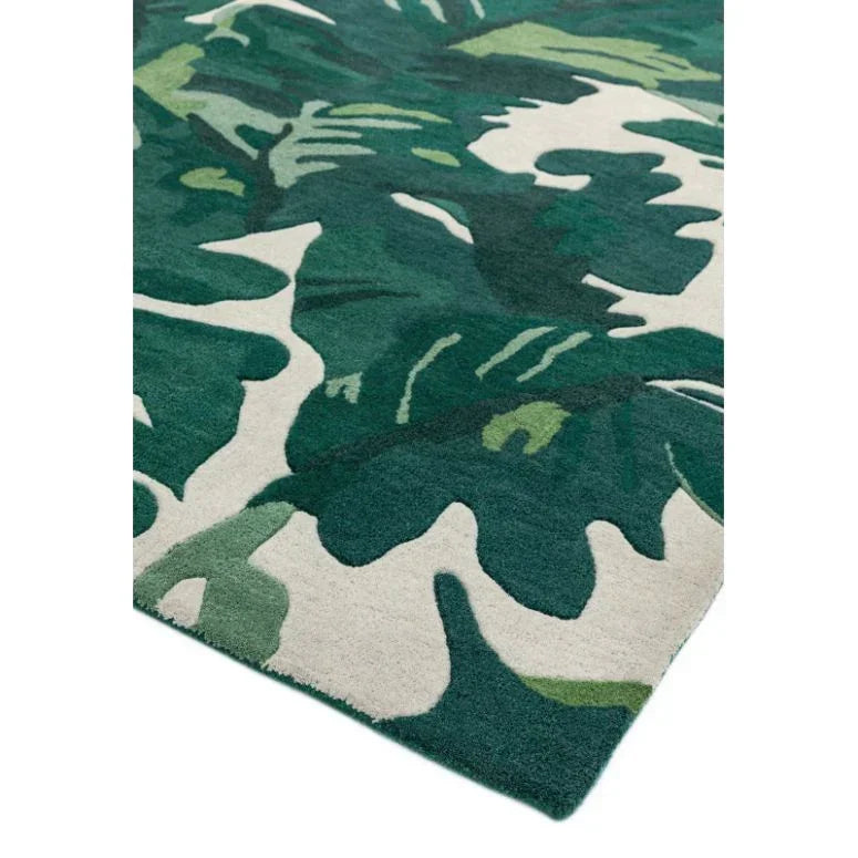 Green leaf patterned area rug with cream background, corner view