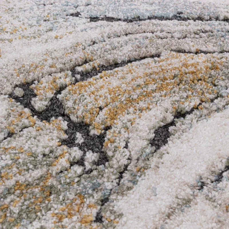 Closeup of plush area rug with abstract pattern in grey, yellow, and cream tones