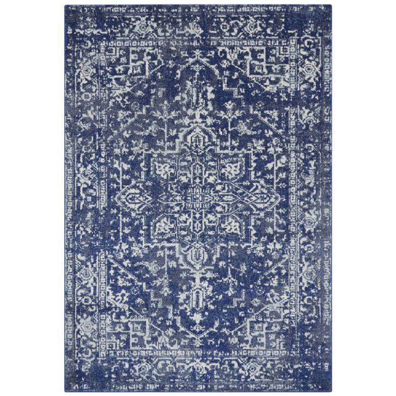 Blue patterned area rug with vintage distressed design and ornate white detailing