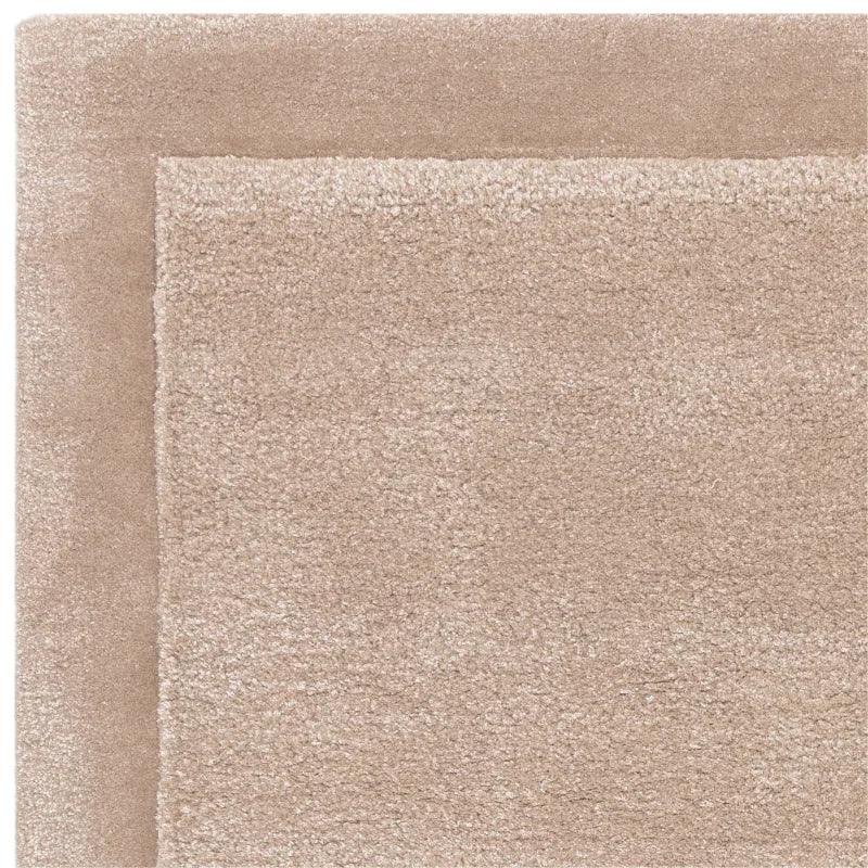 Closeup of beige shaggy rug with soft pile and matching border texture