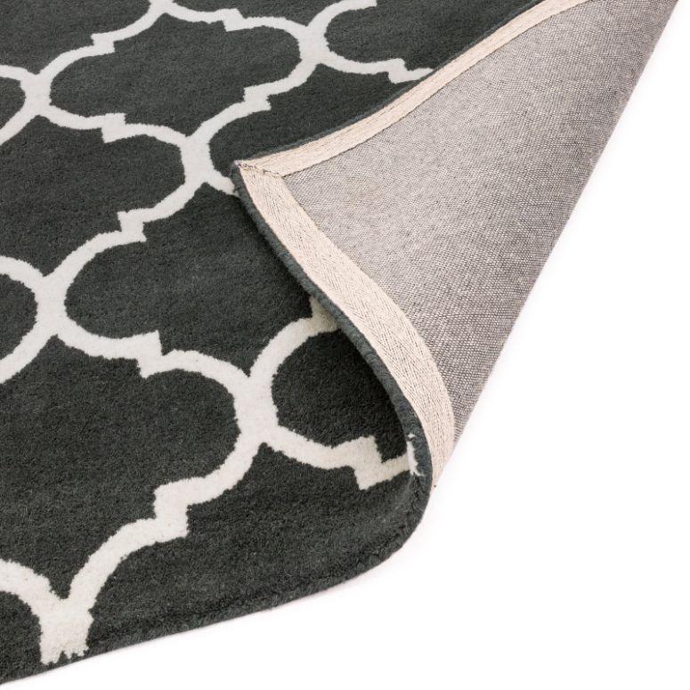 Grey and white patterned rug with corner flipped to show backing material
