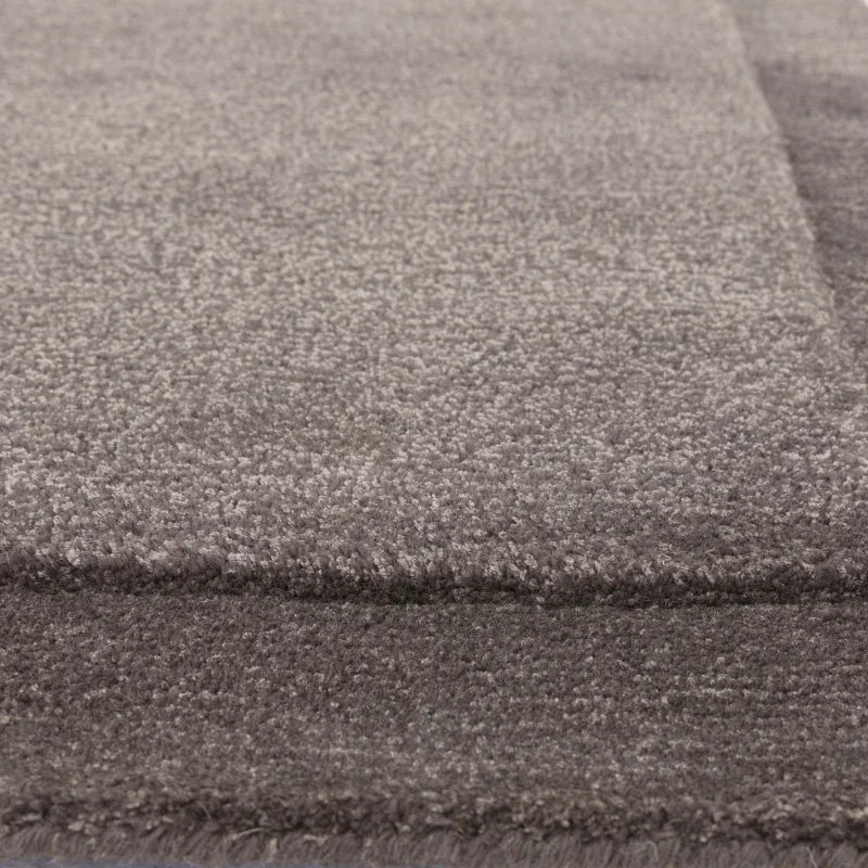 Closeup of grey area rug with soft textured pile and subtle rectangular pattern