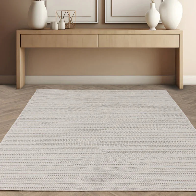 Light grey area rug with subtle stripe pattern on wood floor in modern living room