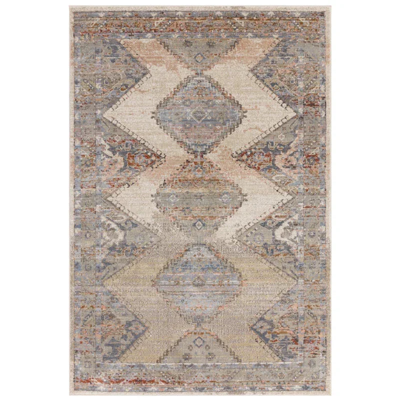 Geometric patterned area rug with blue, beige, and rust tones and distressed texture