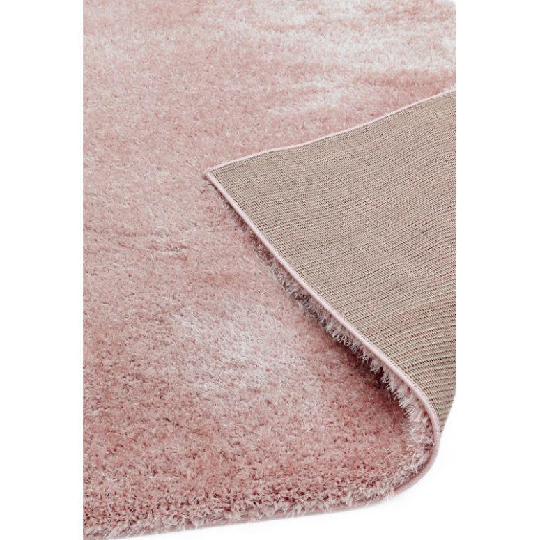 Blush pink shaggy rug with soft pile and corner showing textured backing detail