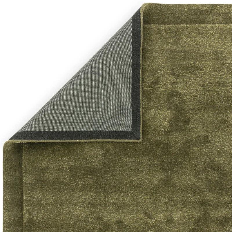 Olive green area rug corner showing pile texture and woven backing detail